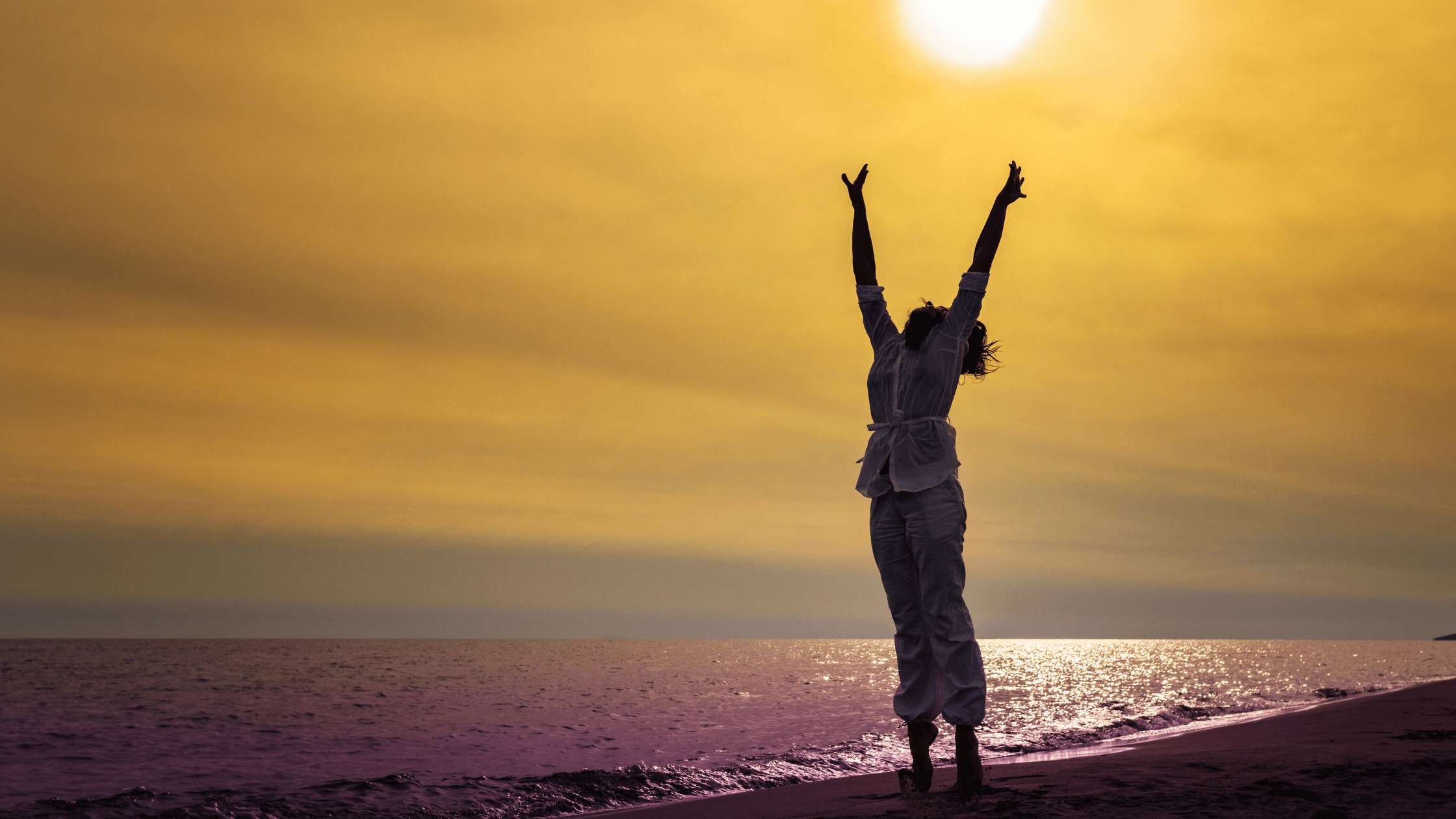 Silhouette of a feminine figure against a beach skyline, arms raised with the sun shining down to illustrate Spring Fatigue: Boosting Energy Naturally with Acupuncture & TCM